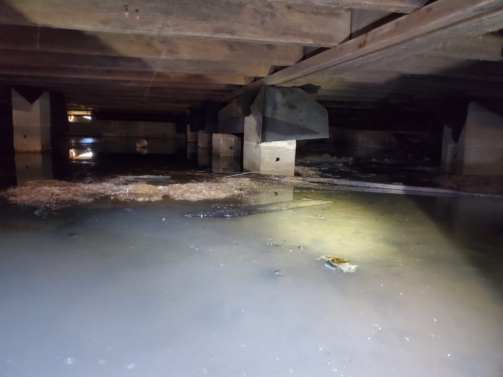 Standing water in a flooded crawl space after a Knoxville storm